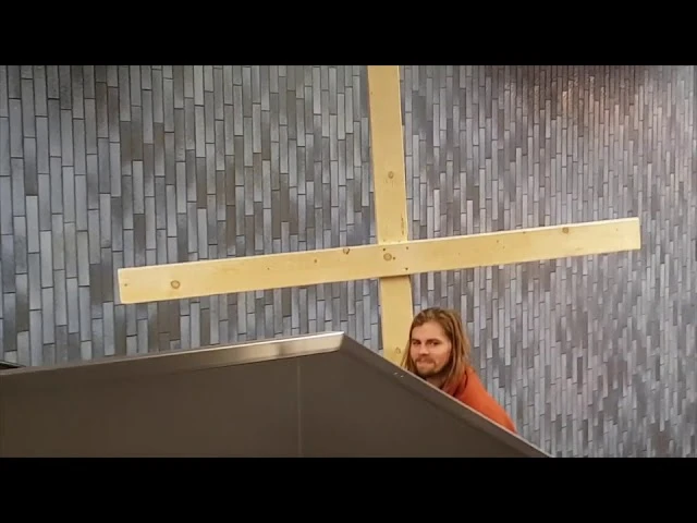 Иисус Христос едет на эскалаторе с крестом в руках